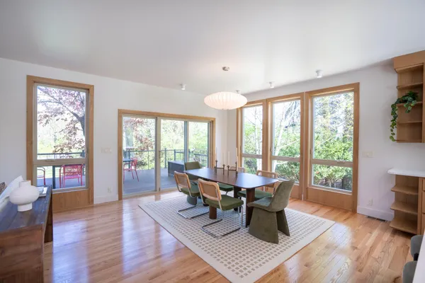a dining room with wooden floor and white walls