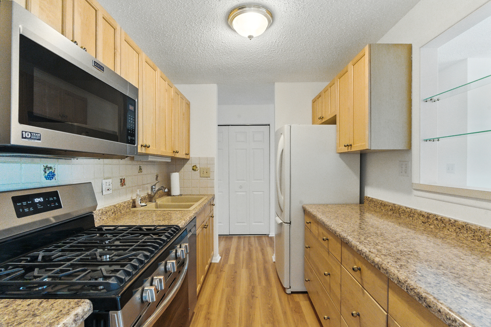 1207 South Old Wilke Road, Unit 303 Rolling Meadows, IL 60005 - Photo 11 of 34 a kitchen with stainless steel appliances granite countertop a stove a sink and a microwave
