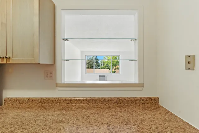 a view of a small space with wooden floor and a window