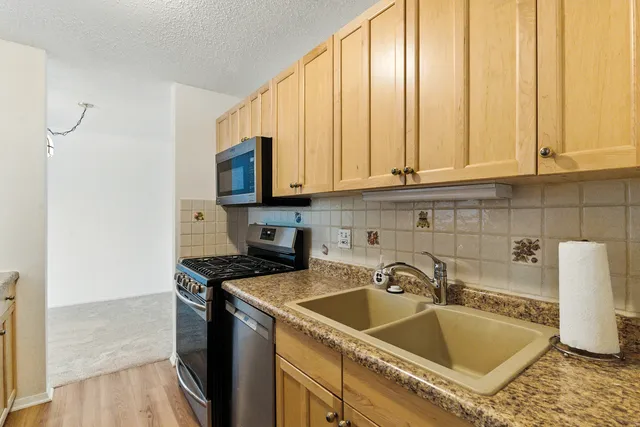 a kitchen with granite countertop a sink a stove and cabinets