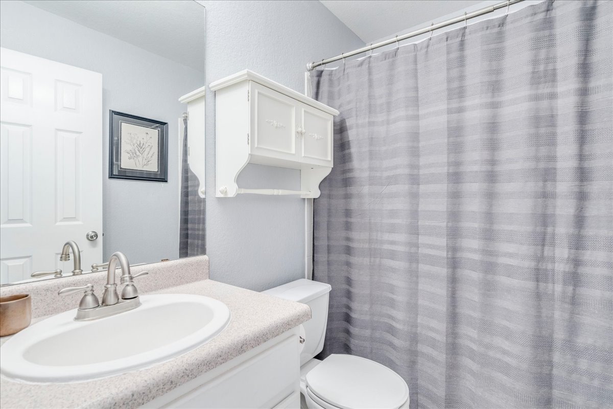 175 Wetzel Kyle, TX 78640 - Photo 23 of 27 A well-appointed bathroom features a practical vanity with an integrated sink and a clean, functional toilet.
