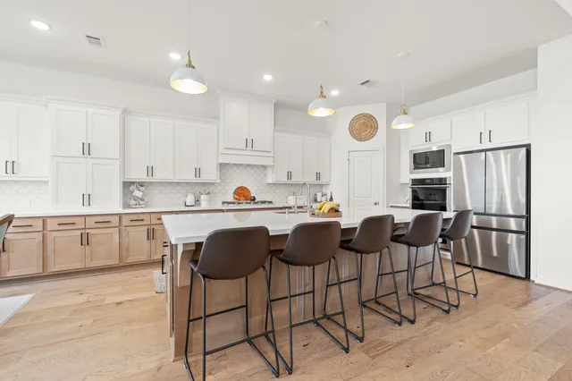 a large white kitchen with sink a stove and a window
