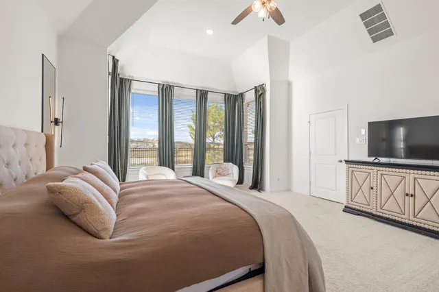 a spacious bedroom with a bed and a large window