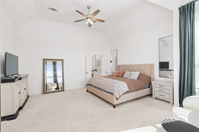 a bedroom with a large bed and a flat screen tv