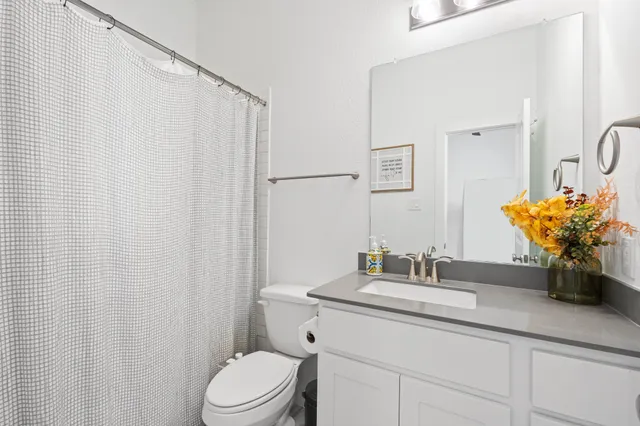 a bedroom with a bed potted plant on the dresser and a window