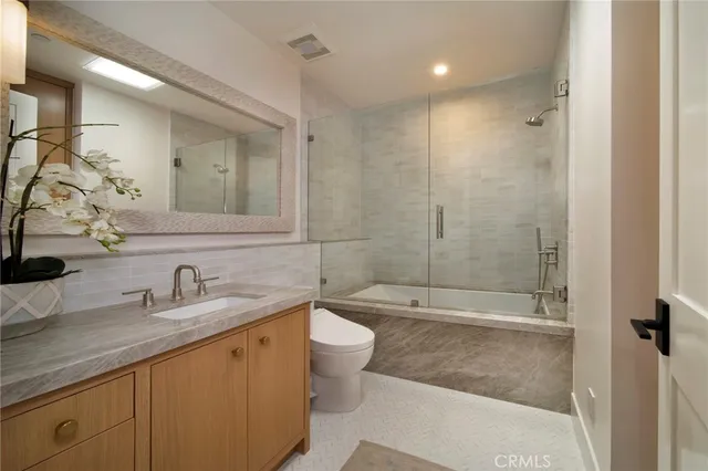 a bathroom with a double vanity sink toilet and shower