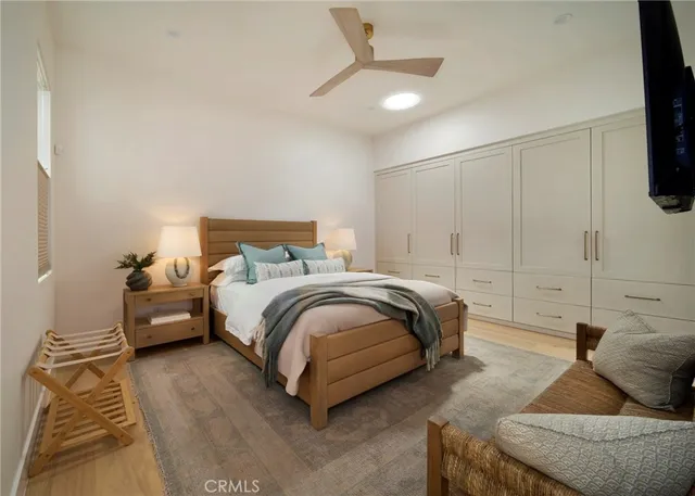 a spacious bedroom with a bed and a flat screen tv