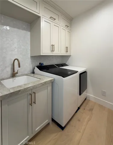 a utility room with sink dryer and washer