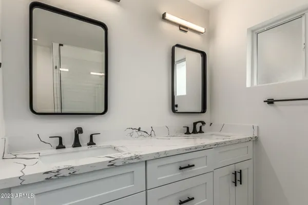 a bathroom with double vanity sinks and a mirror