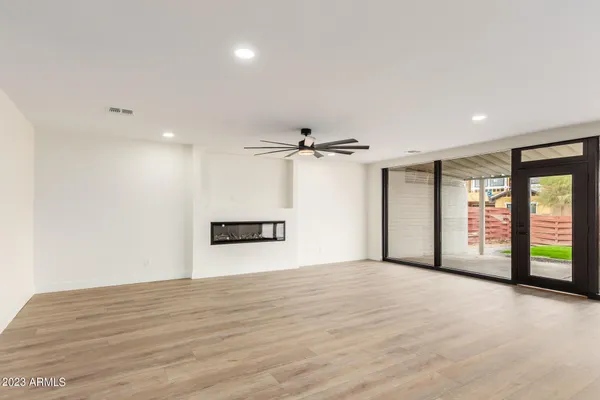 a view of a livingroom with a ceiling fan window and wooden floor