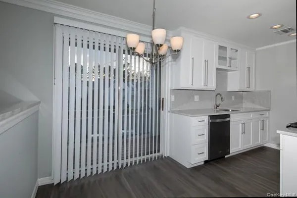 a kitchen with a sink cabinets and wooden floor