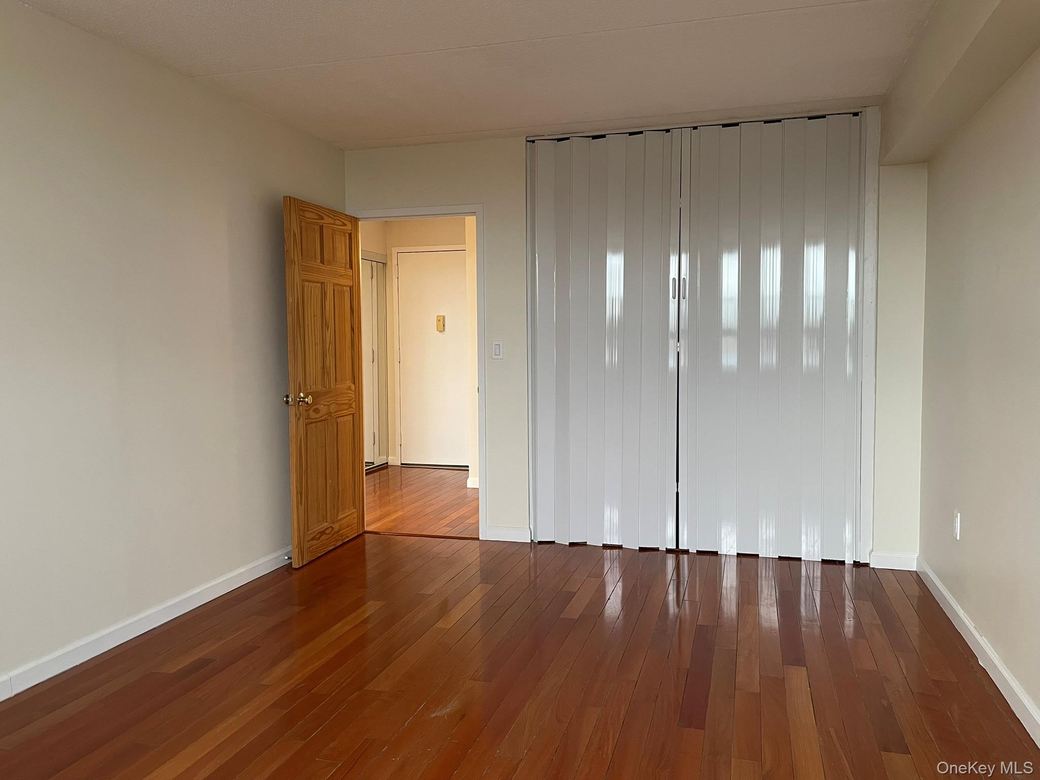 301 West 110th Street, Unit 14F Manhattan, NY 10026 - Photo 11 of 18 wooden floor in a hall with an empty room