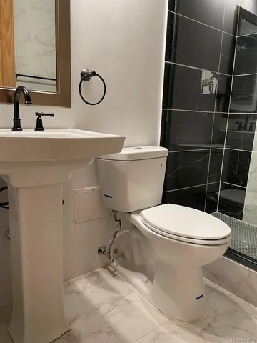 a bathroom with a toilet sink and mirror