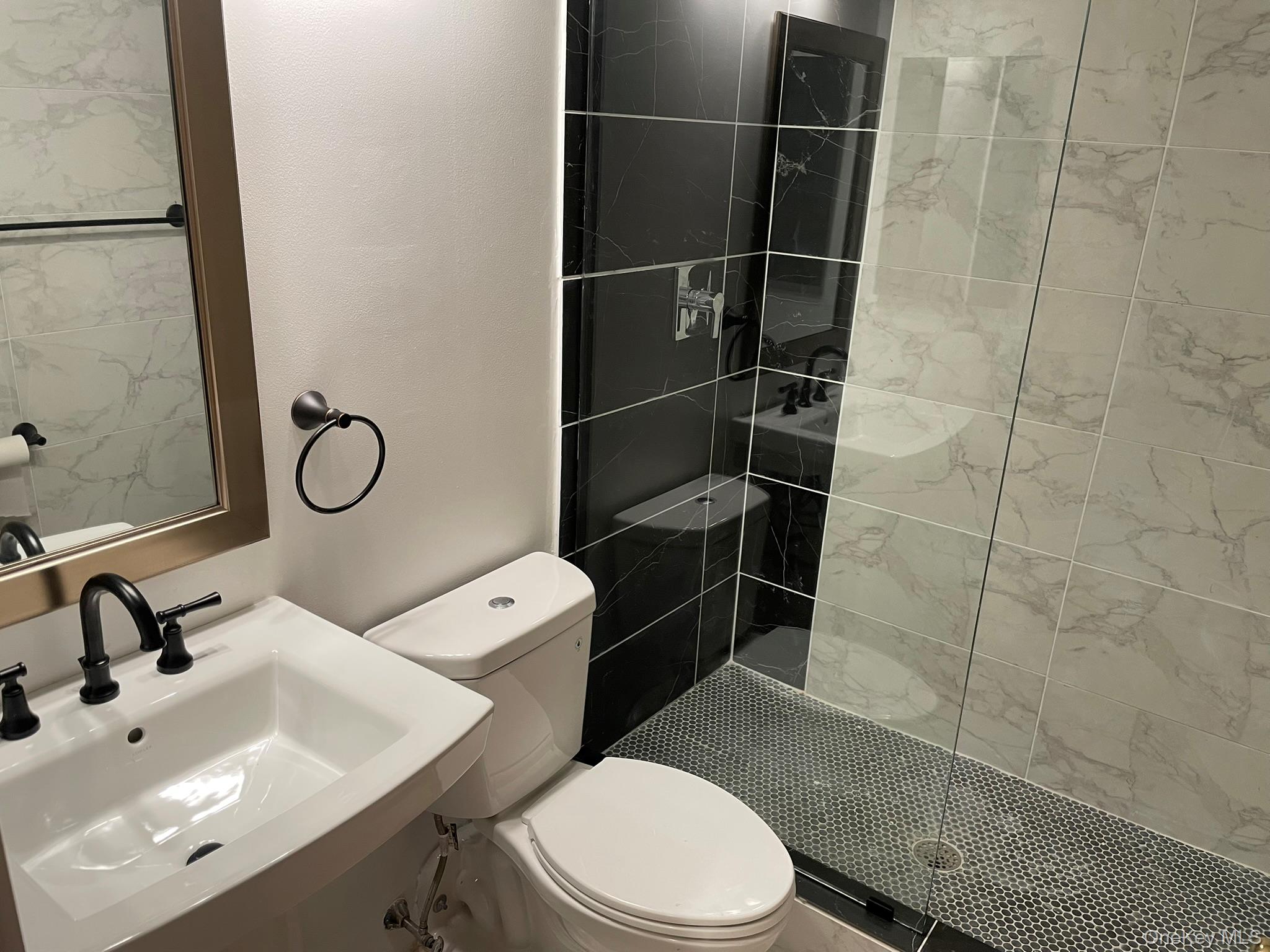 301 West 110th Street, Unit 14F Manhattan, NY 10026 - Photo 14 of 18 a bathroom with a toilet a sink and mirror