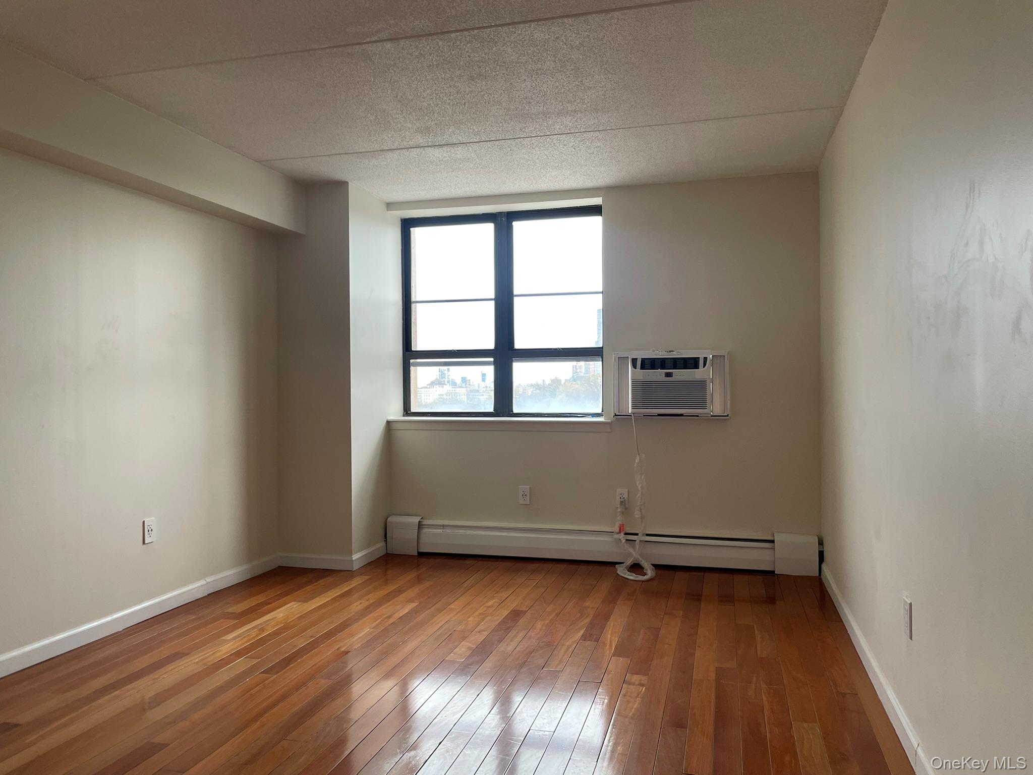 301 West 110th Street, Unit 14F Manhattan, NY 10026 - Photo 10 of 18 wooden floor and window in an empty room