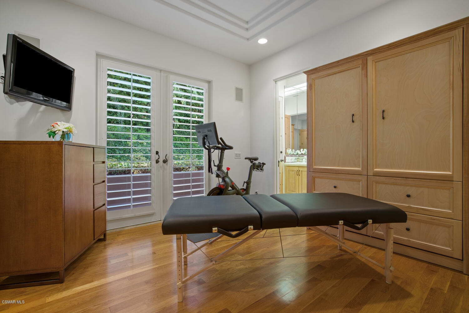 6021 John Muir Road Hidden Hills, CA 91302 - Photo 37 of 74 a room with gym equipment and a flat screen tv