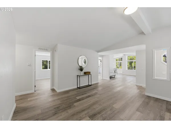 a view of empty room with window and wooden floor