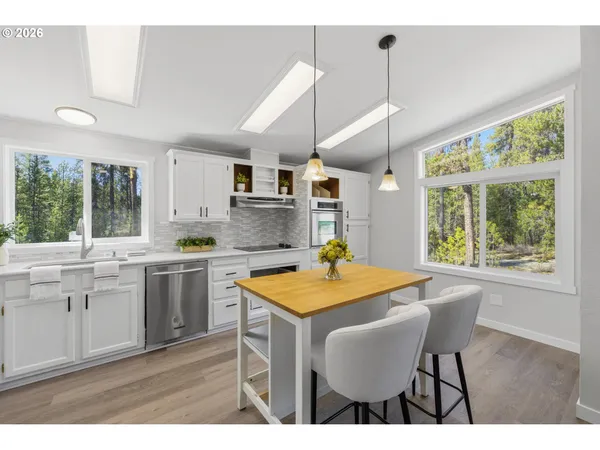 a kitchen with stainless steel appliances granite countertop a stove a sink and a white refrigerator with wooden cabinets