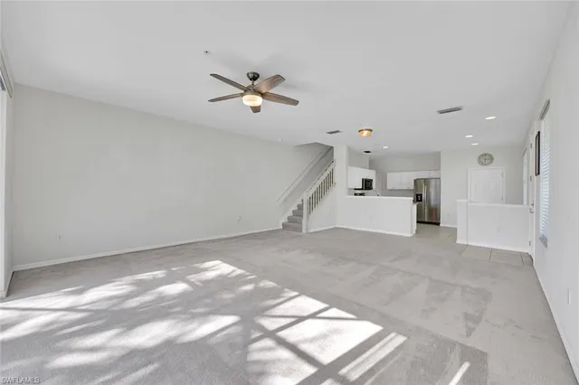 a view of a big room with a ceiling fan and window