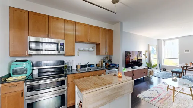 a kitchen with stainless steel appliances a stove a sink a microwave and cabinets