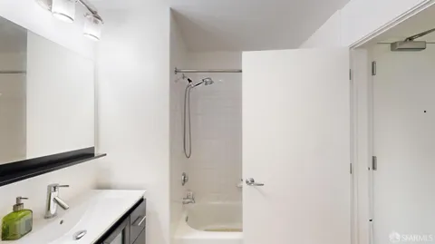 a bathroom with a granite countertop sink mirror and shower