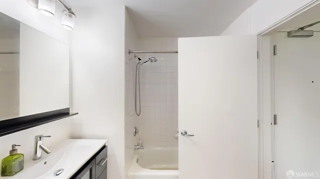 a bathroom with a granite countertop sink mirror and shower