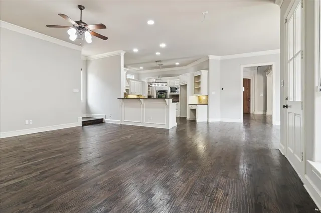 a view of a room with wooden floor and a kitchen