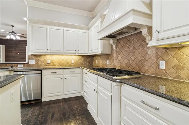 a kitchen with granite countertop a sink stove and cabinets