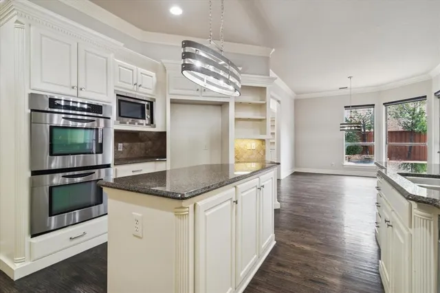 a kitchen with stainless steel appliances kitchen island granite countertop a stove and a sink