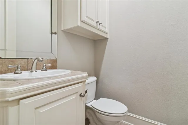 a bathroom with a sink a toilet and a mirror