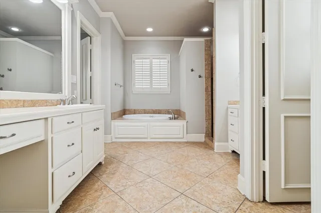 a spacious bathroom with a double vanity sink a mirror and a bathtub