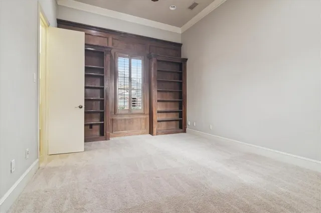 an empty room with closet and windows