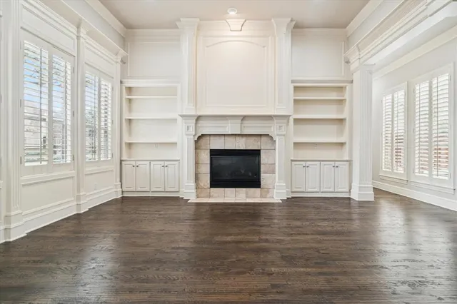 a view of an empty room with a window and fireplace