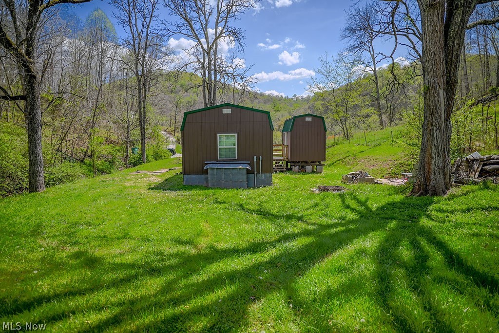 1547 Providence Road Elizabeth, WV 26143 - Photo 22 of 32 Two brown outbuildings with green trim situated on a grassy landscape with mature trees