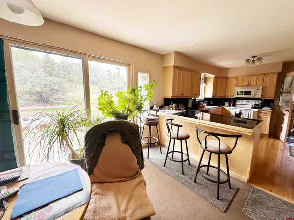 a dining room with furniture and a large window