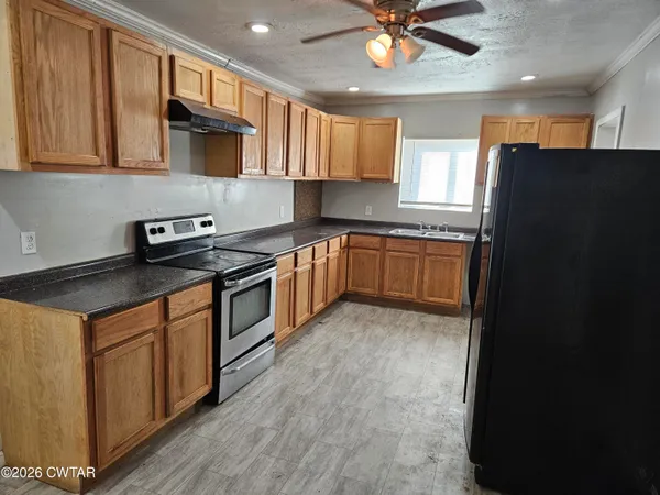 a kitchen with stainless steel appliances granite countertop a stove cabinets and refrigerator