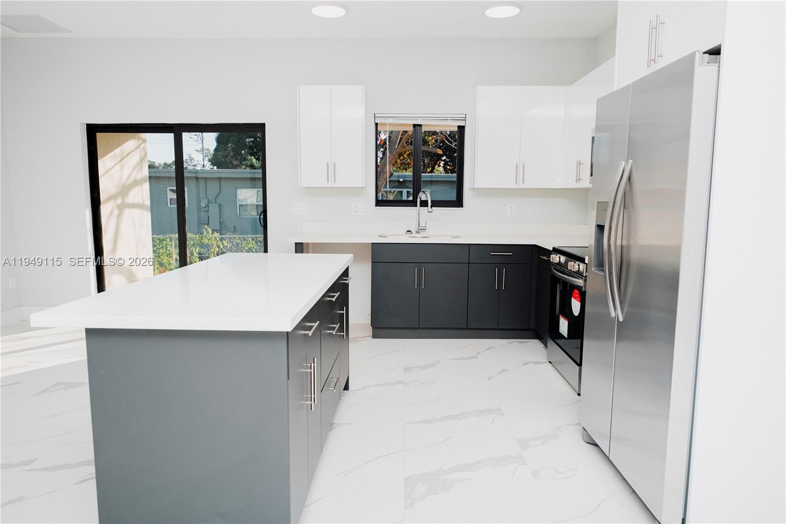 820 Northwest 18th Avenue Pompano Beach, FL 33069 - Photo 35 of 46 a kitchen with stainless steel appliances kitchen island sink refrigerator and stove