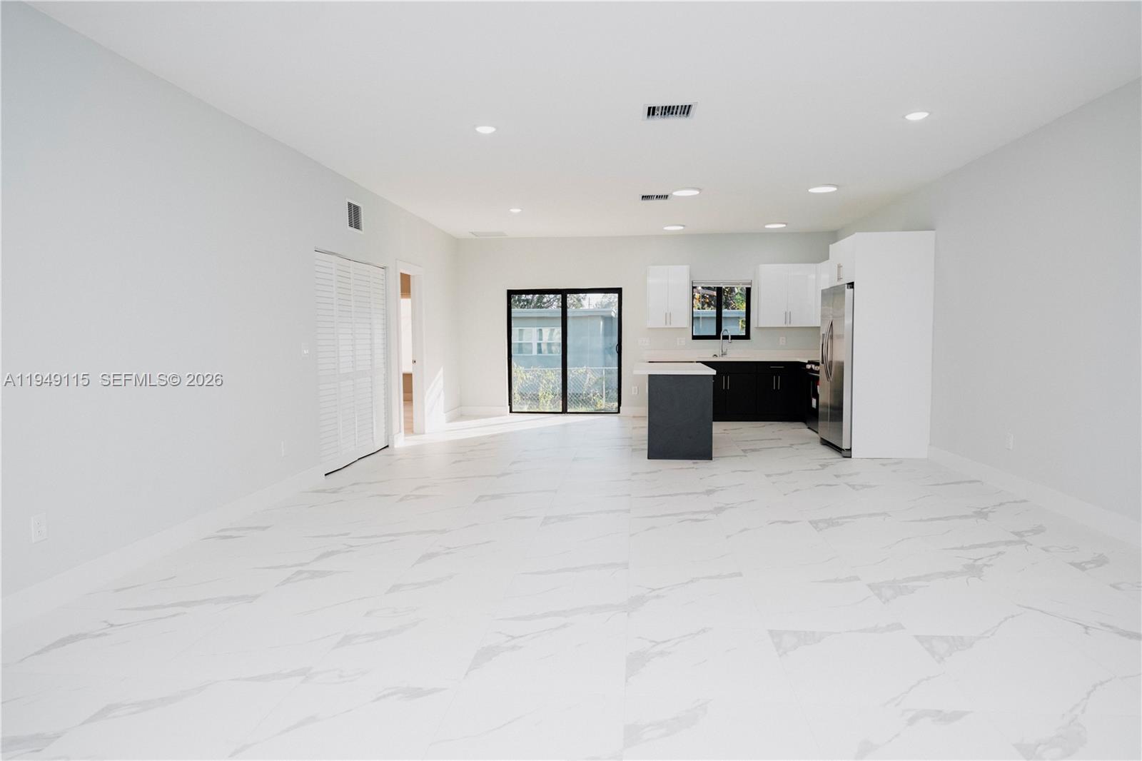 820 Northwest 18th Avenue Pompano Beach, FL 33069 - Photo 40 of 46 a large white kitchen with kitchen island a sink a refrigerator and a stove