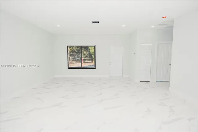 a large white kitchen with a large window