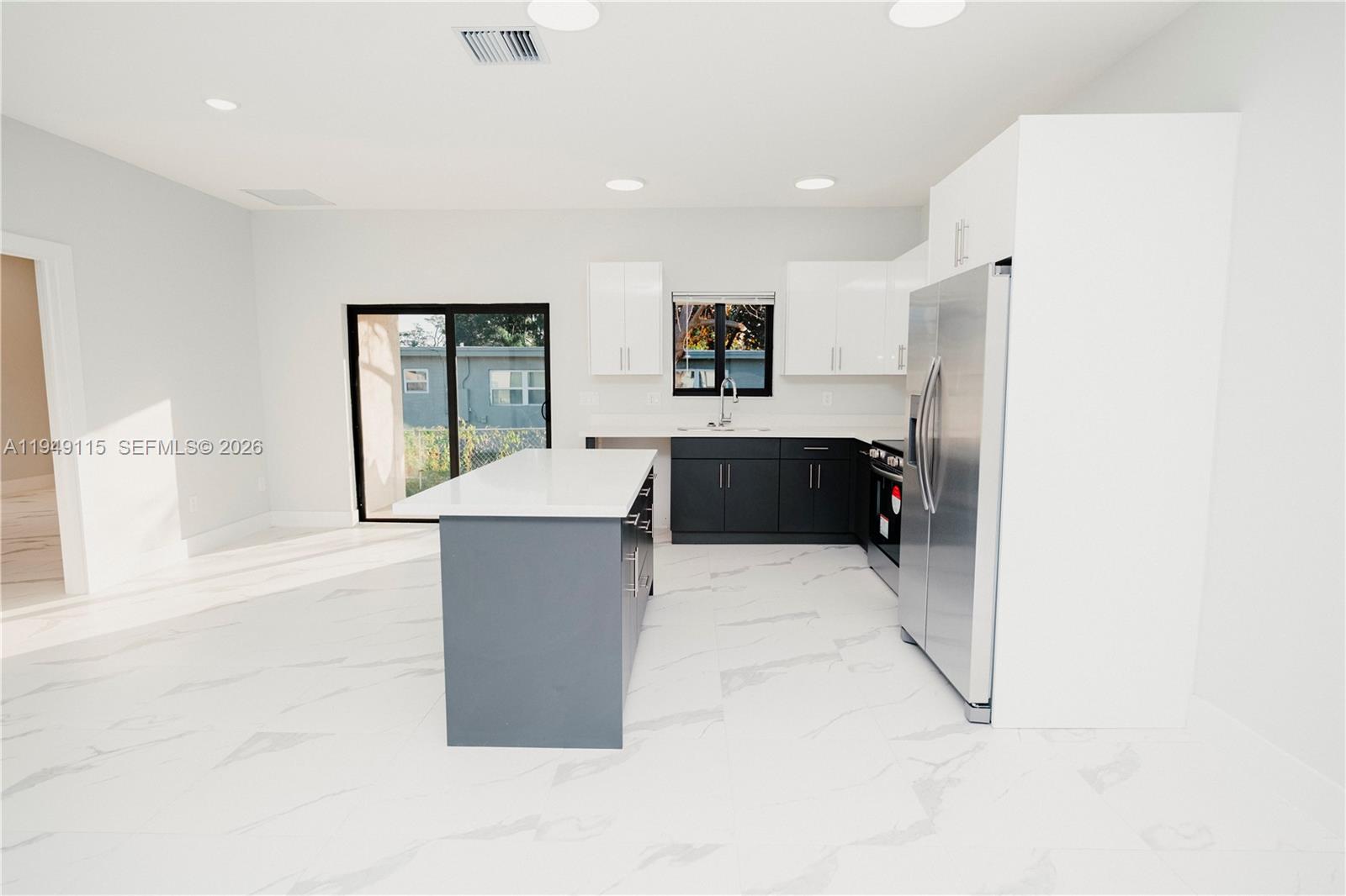 820 Northwest 18th Avenue Pompano Beach, FL 33069 - Photo 7 of 46 a large white kitchen with a large window