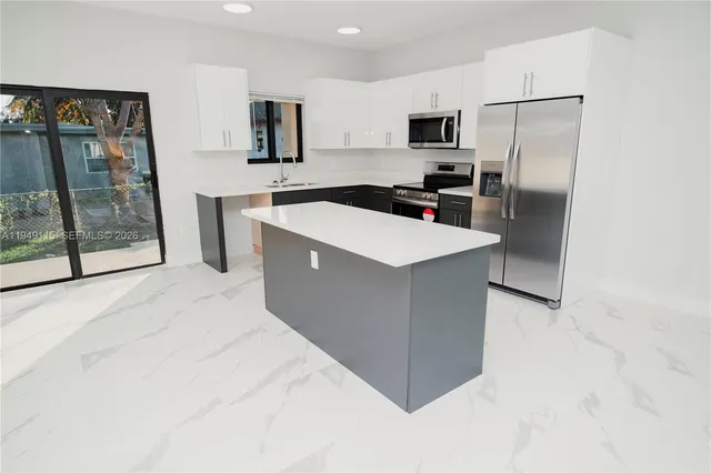 a kitchen with a appliances a sink and a refrigerator