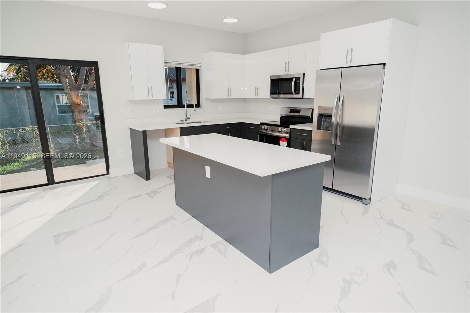 820 Northwest 18th Avenue Pompano Beach, FL 33069 - Photo 8 of 46 a kitchen with stainless steel appliances a refrigerator sink and microwave