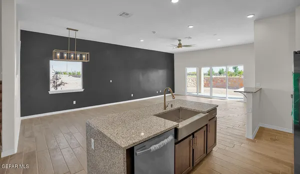 a kitchen with stainless steel appliances kitchen island granite countertop a refrigerator a stove and a sink