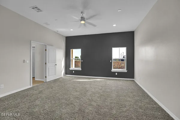 a view of an empty room and a ceiling fan