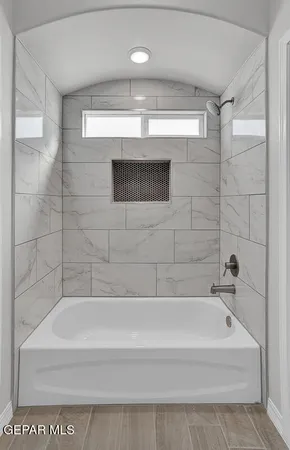 a bathroom with a tub sink and mirror