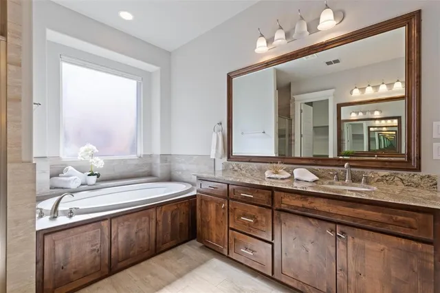 a spacious bathroom with a double vanity sink tub and a mirror