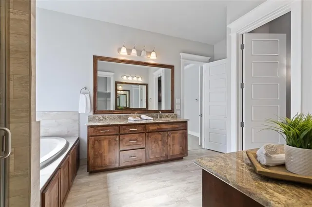 a bathroom with a granite countertop sink a mirror and a shower