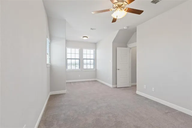 a kitchen with white cabinets and a window