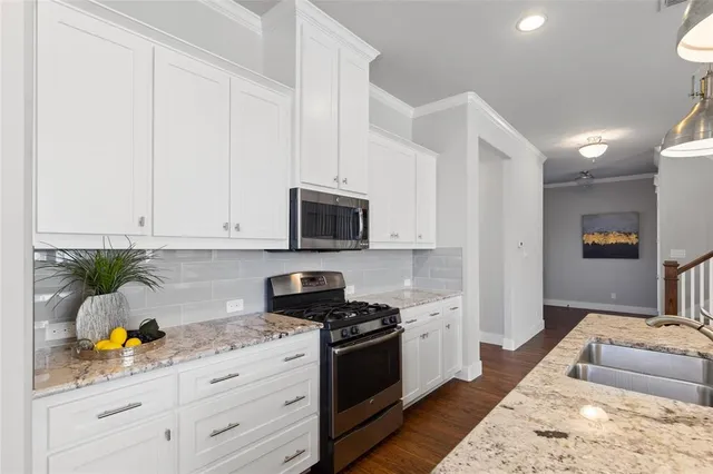 a kitchen with kitchen island a sink a stove and chairs