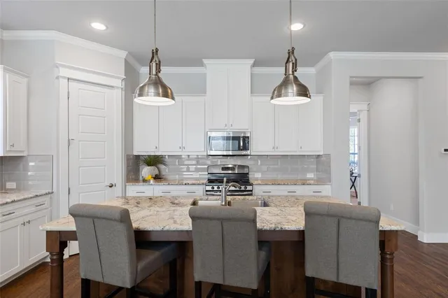 a kitchen with stainless steel appliances granite countertop a sink a stove and a refrigerator